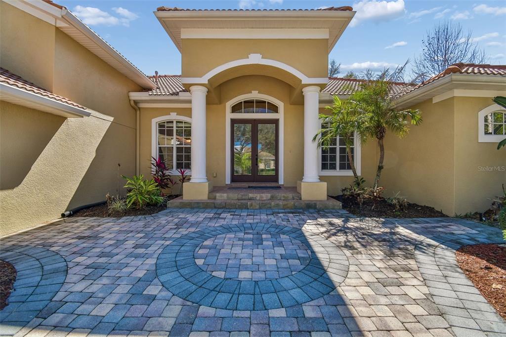 The exterior of a house features a paved circular driveway leading to a columned entryway — 614 VINTAGE WAY, BRANDON, FL