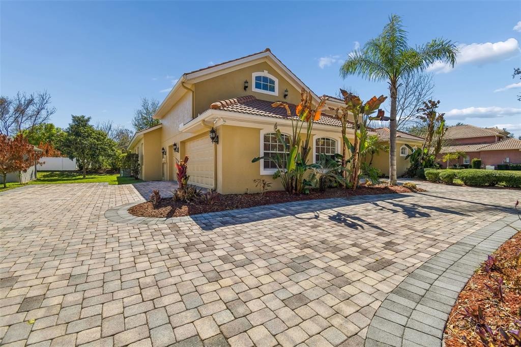 A tan house with a tiled roof, a paved driveway, and a palm tree in front — 614 VINTAGE WAY, BRANDON, FL