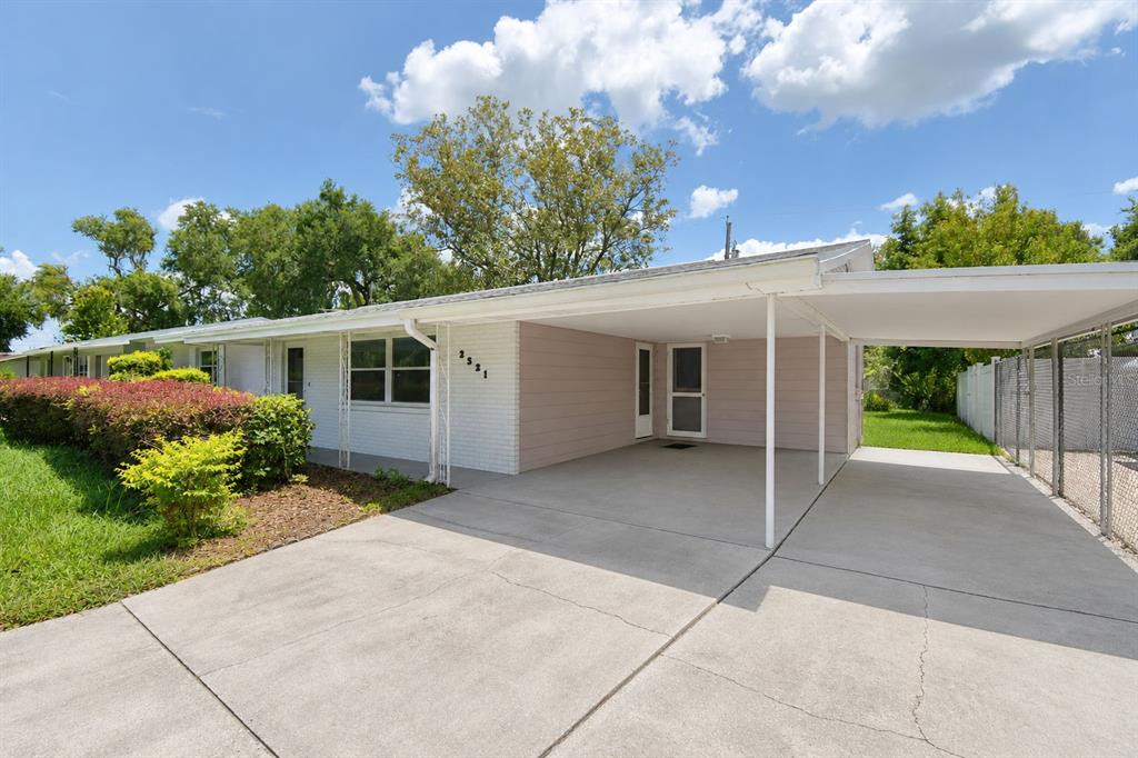 A single-story house with a white brick facade, a concrete driveway, and an attached carport — 2521 MCCRANIE PLACE, LAKELAND, FL