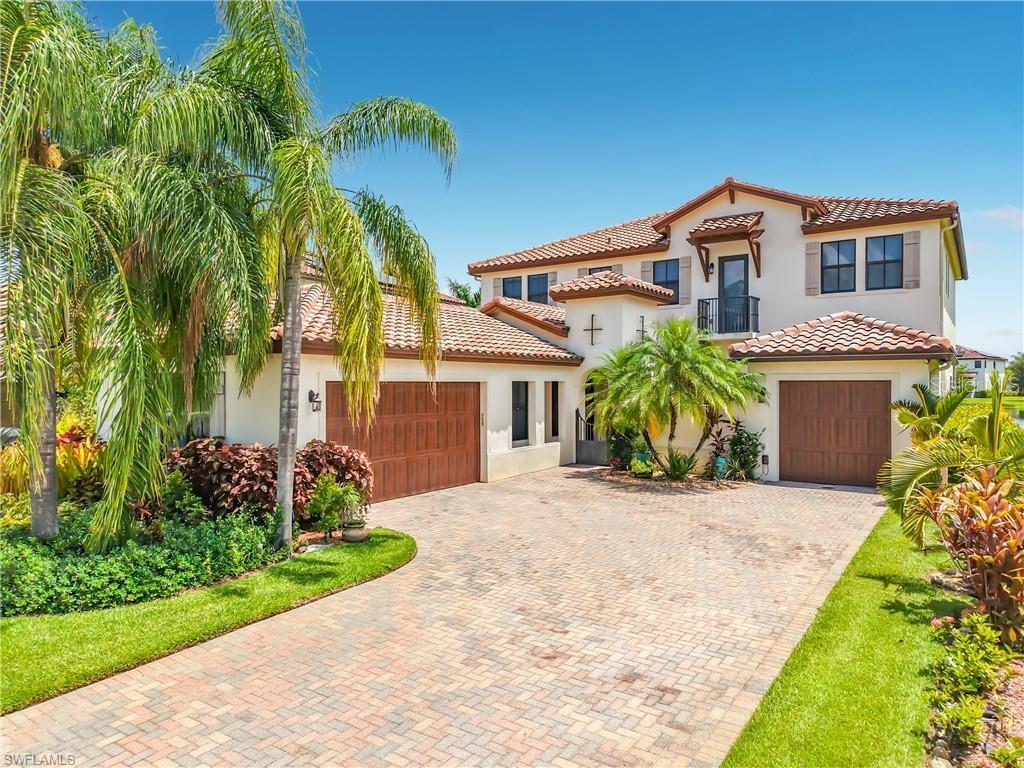 A two-story stucco house features a tile roof, two garage doors, and a paved driveway — 5024 MILANO STREET, AVE MARIA, FL