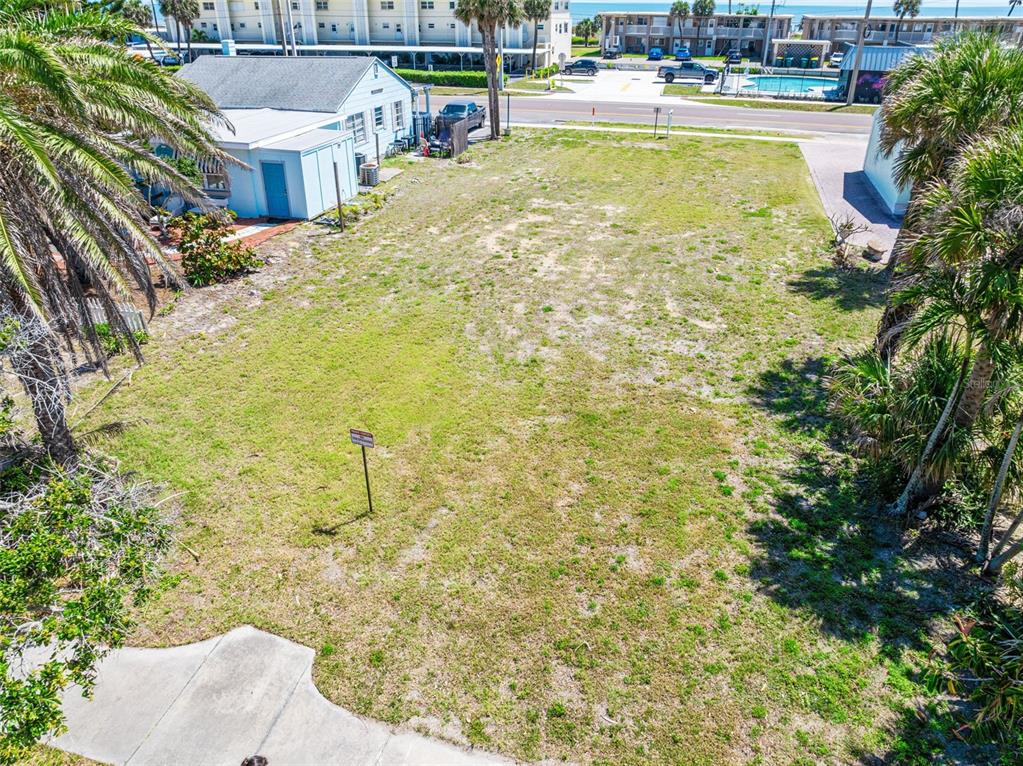 An elevated view shows a vacant, grassy rectangular lot situated between two existing buildings — 118 N ATLANTIC, COCOA BEACH, FL