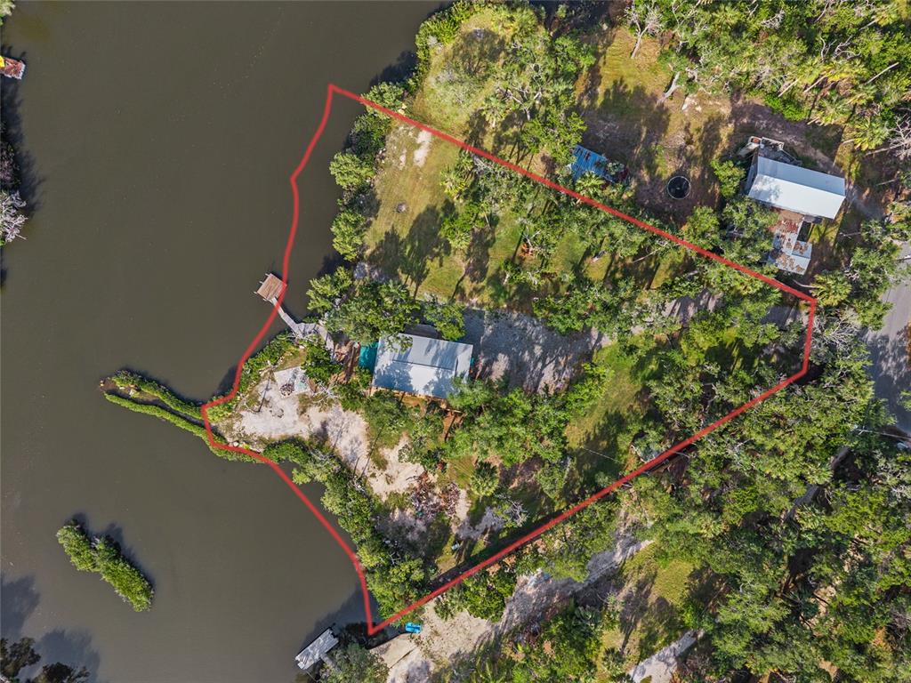 An aerial view shows a waterfront property with a house, dock, and wooded lot — 1326 S ESTUARY, CRYSTAL RIVER, FL