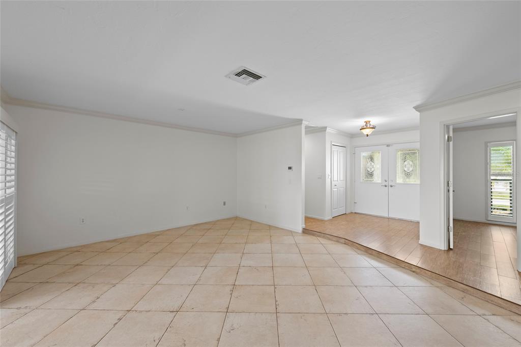 An interior view shows a tiled living area with a raised entryway featuring wood-look flooring — 1252 WATERSIDE LANE, VENICE, FL