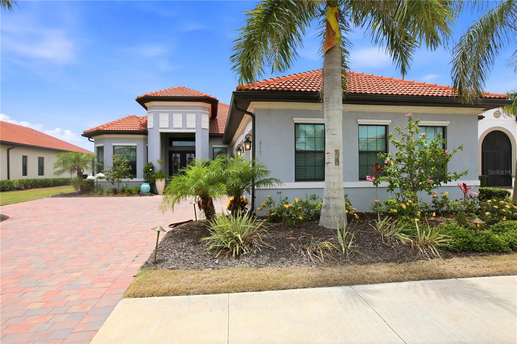 A single-story house with a red tile roof, gray stucco exterior, and a brick driveway — 617 MARAVIYA BOULEVARD, NOKOMIS, FL
