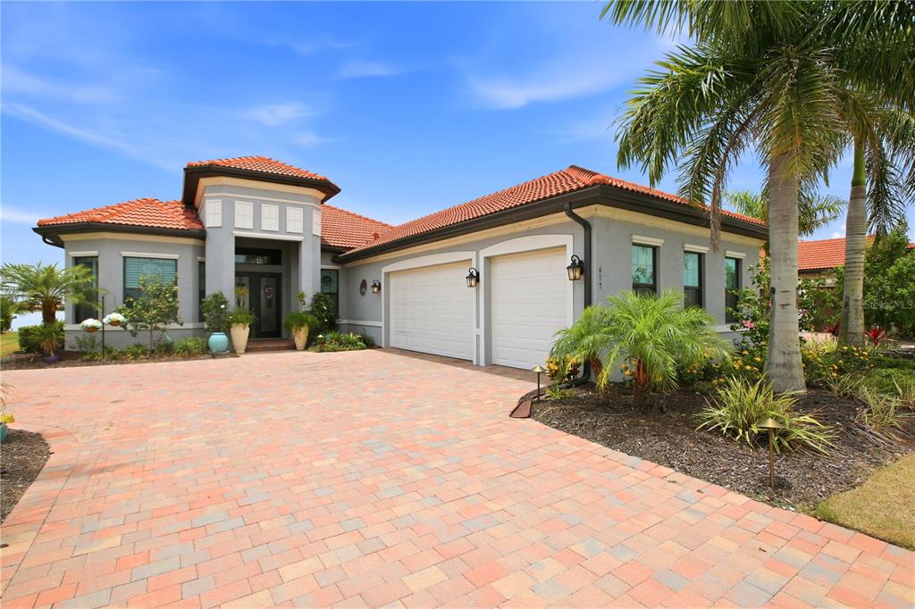 A single-story house with a tiled roof, two-car garage, and a paved driveway — 617 MARAVIYA BOULEVARD, NOKOMIS, FL