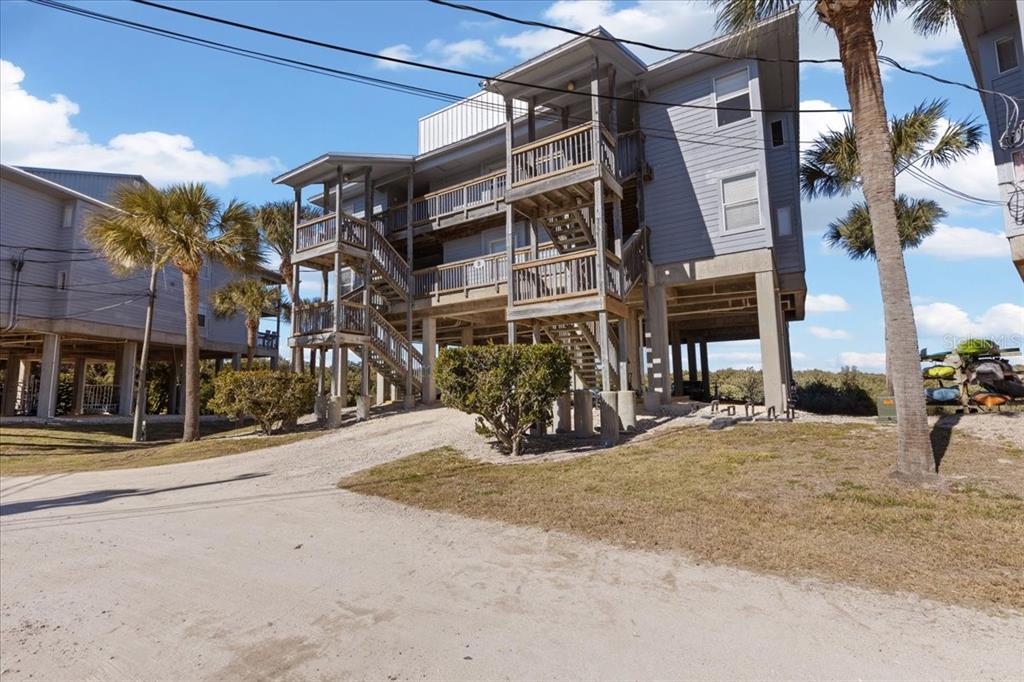 A multi-story house on stilts features wooden balconies and an external staircase — 11 OLD MILL DRIVE UNIT 9C, CEDAR KEY, FL