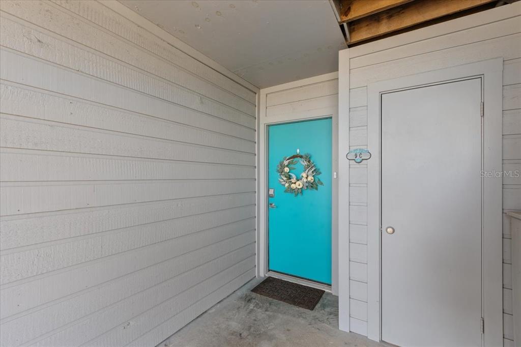 An exterior view shows a turquoise front door with a wreath and an adjacent door — 11 OLD MILL DRIVE UNIT 9C, CEDAR KEY, FL