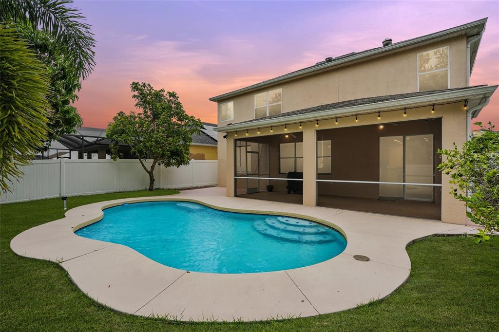 A two-story house with a screened-in patio and a kidney-shaped swimming pool in the backyard — 10043 WINDING RIVER ROAD, PUNTA GORDA, FL