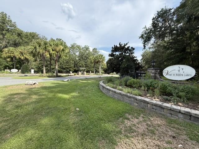 A stone retaining wall borders a grassy lawn leading to the entrance of a neighborhood — TBD NW 148TH LANE, WILLISTON, FL