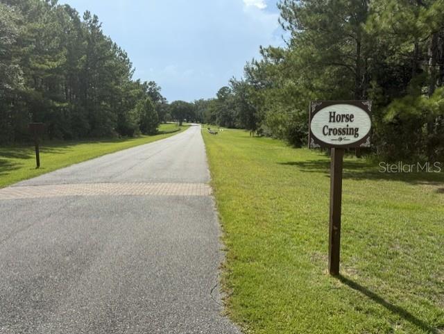A paved road leads through a wooded area with a Horse Crossing sign on the right — TBD NW 148TH LANE, WILLISTON, FL
