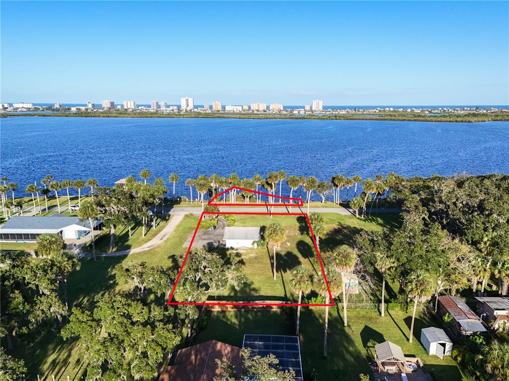 An aerial view shows a waterfront property with a house and a detached red-outlined parcel — 5040 RIVERSIDE DRIVE, PORT ORANGE, FL