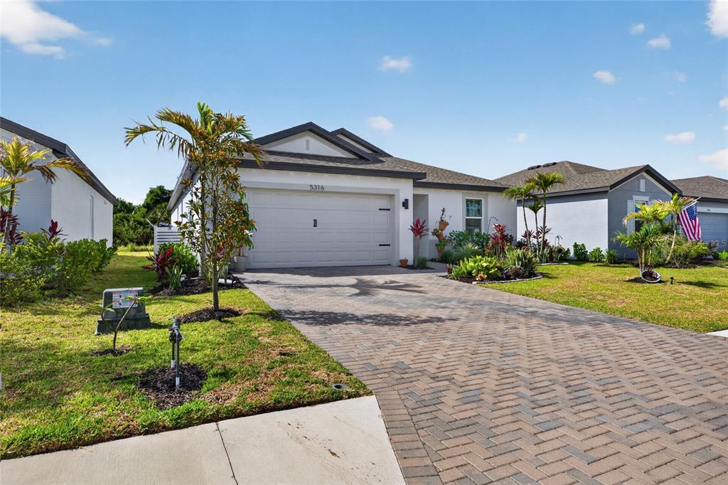 A single-story house with a paved driveway, a two-car garage, and landscaped front yard — 5316 PATANO LOOP, PALMETTO, FL