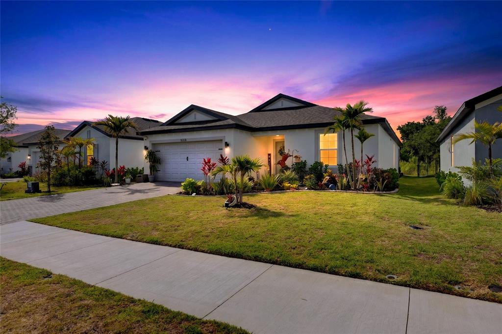 A single-story house with a white exterior, a two-car garage, and a landscaped front yard — 5316 PATANO LOOP, PALMETTO, FL