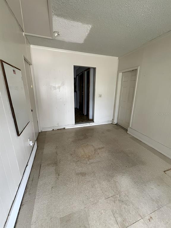 An empty room with white paneled walls, a tiled floor, and two doorways — 8118 ESPERANZA STREET, ORLANDO, FL