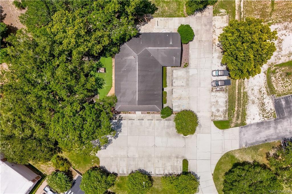 An aerial view shows a commercial building with a large parking lot and surrounding trees — 3628 N LECANTO HIGHWAY, BEVERLY HILLS, FL