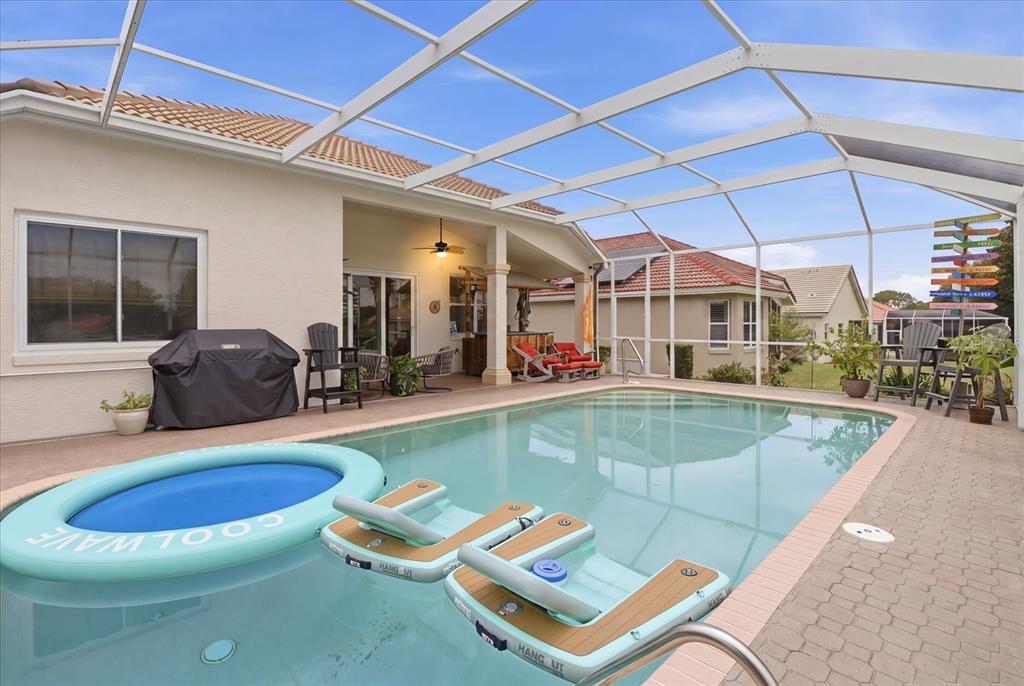 A screened-in swimming pool patio features a covered lanai, outdoor furniture, and inflatable pool floats — 1096 W DIAMOND SHORE LOOP, HERNANDO, FL