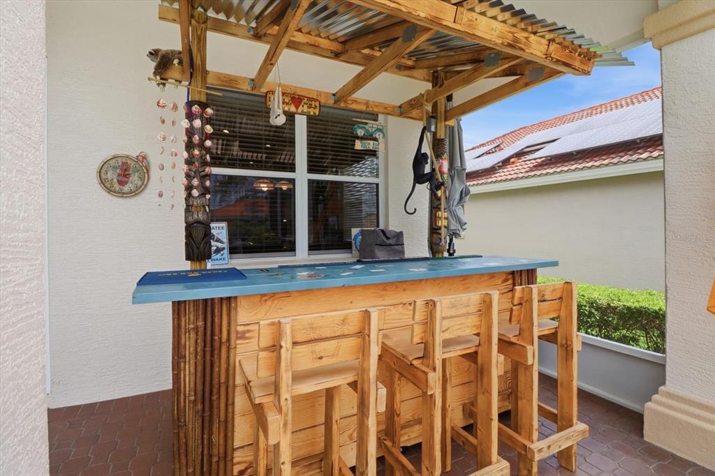 A wooden tiki bar with stools sits on a paved patio under a covered roof — 1096 W DIAMOND SHORE LOOP, HERNANDO, FL