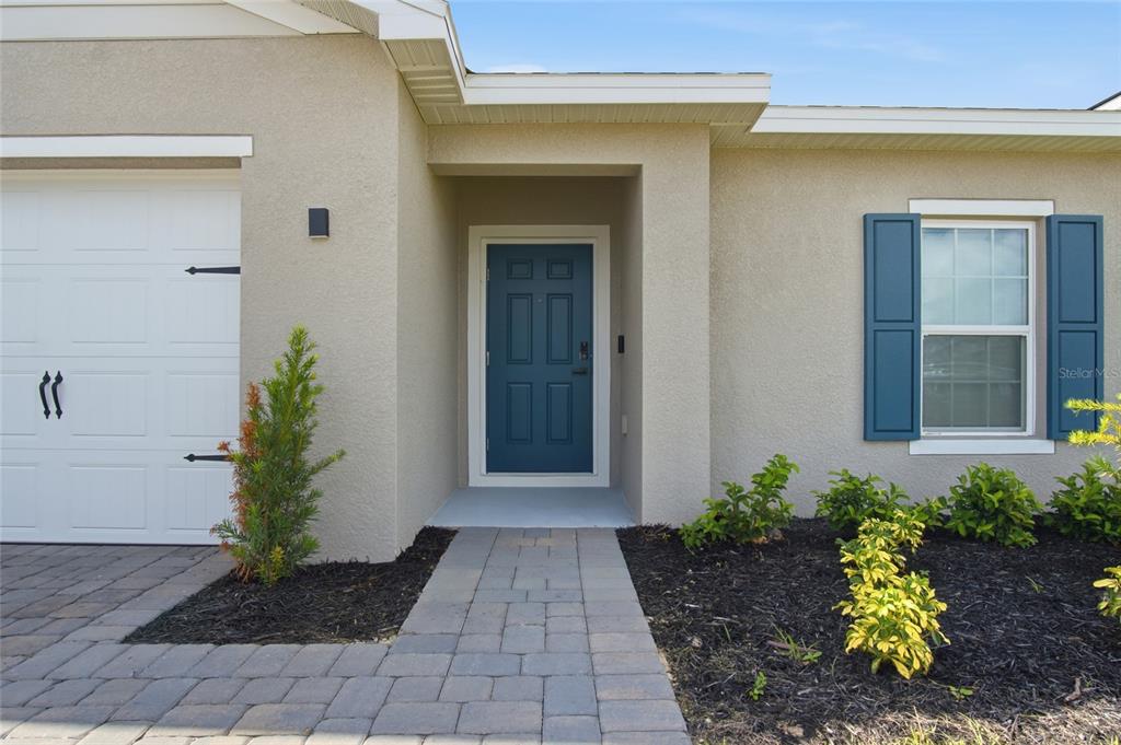 The exterior of a house features a blue front door, a garage, and a walkway — 724 CANTABERRY DRIVE, DUNDEE, FL
