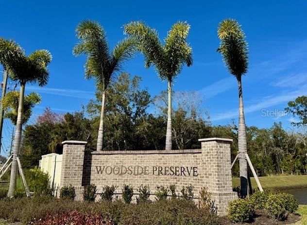 A brick community entrance sign for Woodside Preserve stands beneath three tall palm trees — 8074 TIMBERWOOD LANE, ORLANDO, FL