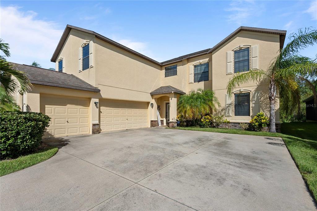 A two-story house with a three-car garage and a large concrete driveway — 5049 IVORY STONE DRIVE, WIMAUMA, FL