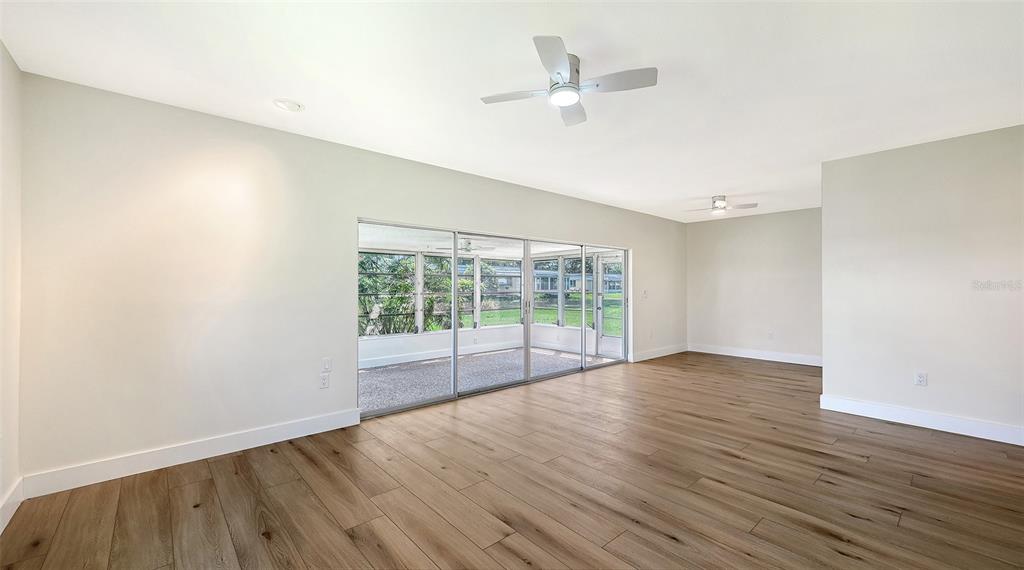 A single-story house exterior with a carport, palm trees, and a lawn at sunset — 5911 TIDEWOOD AVENUE UNIT 3, SARASOTA, FL