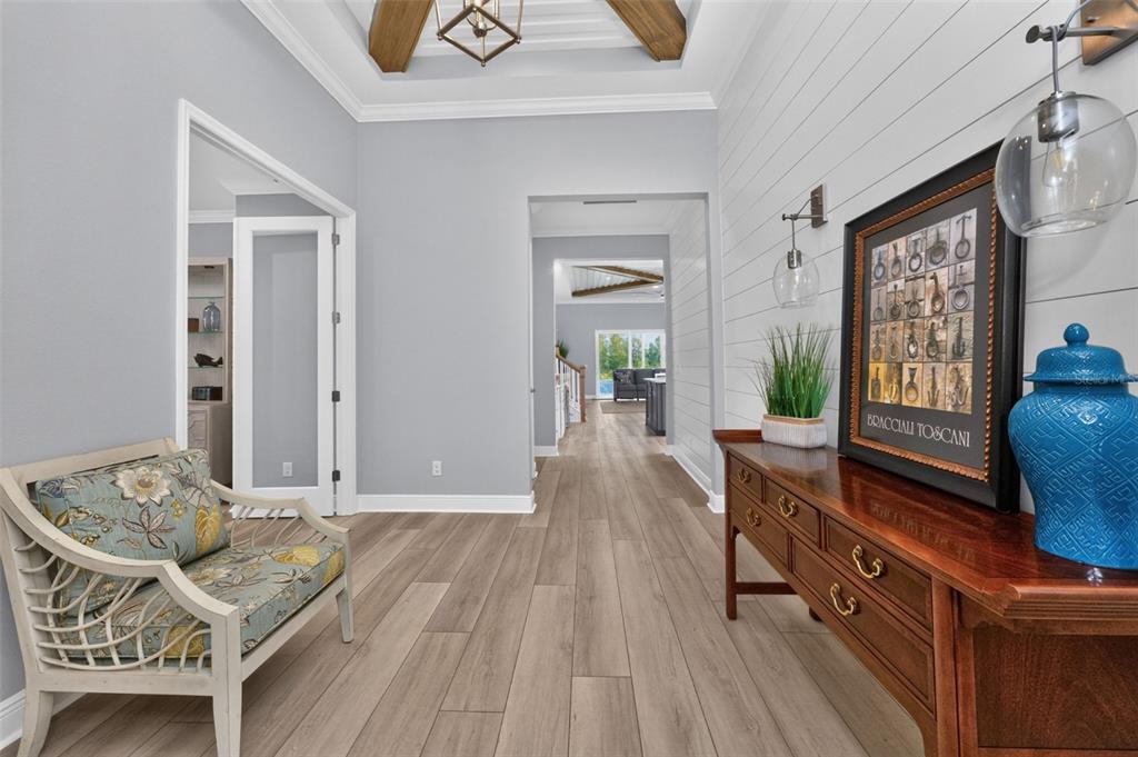 A bright entryway features light wood flooring, shiplap walls, a wooden console table, and seating — 11225 BLISSBY STREET, VENICE, FL