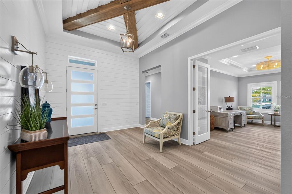 A bright entryway features shiplap walls, a vaulted ceiling with wood beams, and wood flooring — 11225 BLISSBY STREET, VENICE, FL