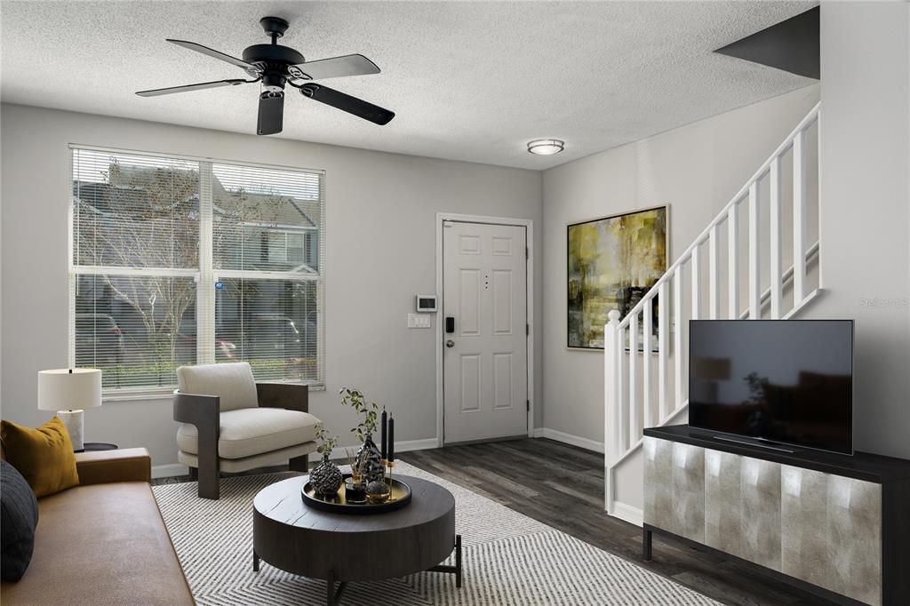 A living room features a ceiling fan, a front door, a staircase, and modern furniture — 6213 OSPREY LAKE CIRCLE, RIVERVIEW, FL