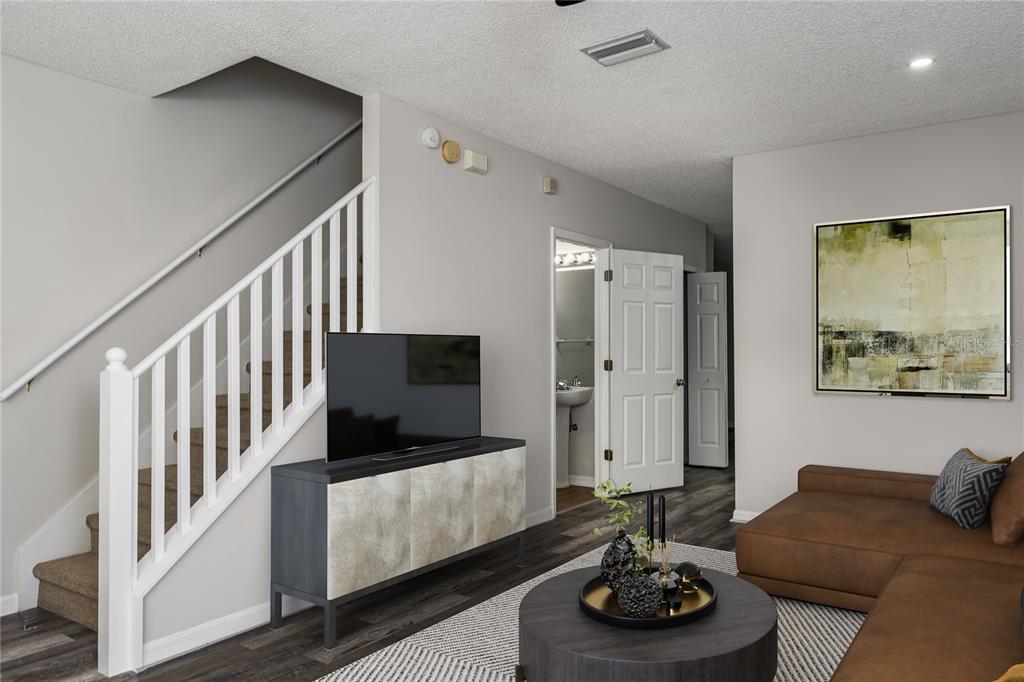 A living room features a staircase, a television on a console, and a brown sofa — 6213 OSPREY LAKE CIRCLE, RIVERVIEW, FL