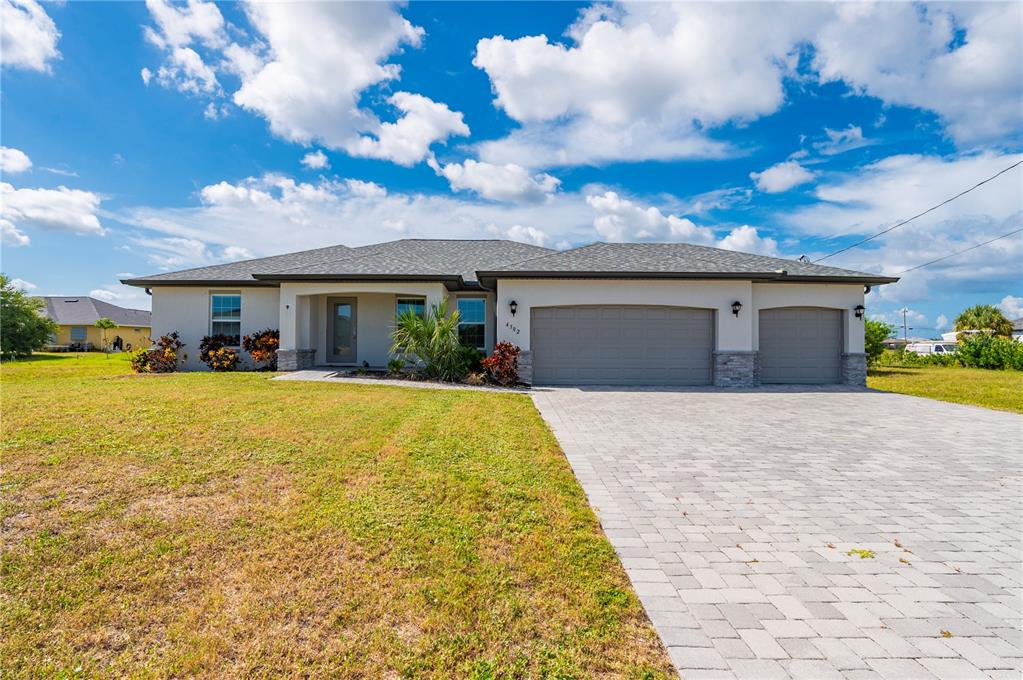 A single-story house with a gray shingled roof, stucco exterior, and a paved driveway — 4302 NW 32ND STREET, CAPE CORAL, FL