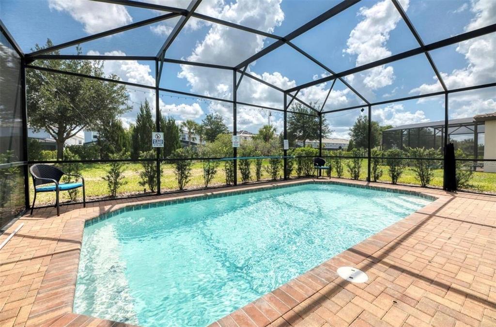 A screened-in swimming pool with a brick paver deck and patio furniture — 5533 MISTY OAK CIRCLE, DAVENPORT, FL