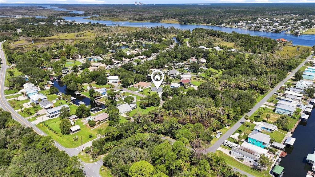 This aerial view shows a residential neighborhood with houses, trees, and a nearby waterway — 11271 W CORAL COURT, CRYSTAL RIVER, FL