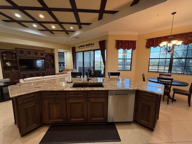 A kitchen island with a granite countertop and dark wood cabinets sits in an open room — 5508 SUMMIT POINTE CIRCLE UNIT 104, BRADENTON, FL