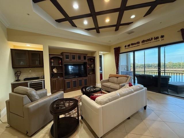 A living room features a coffered ceiling, built-in cabinetry, and a view of a pool — 5508 SUMMIT POINTE CIRCLE UNIT 104, BRADENTON, FL