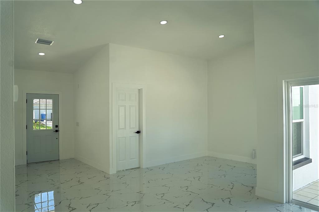 An interior view of a room with white walls, recessed lighting, and white marble-patterned flooring — 9224 CAMINO VILLA BOULEVARD, TAMPA, FL