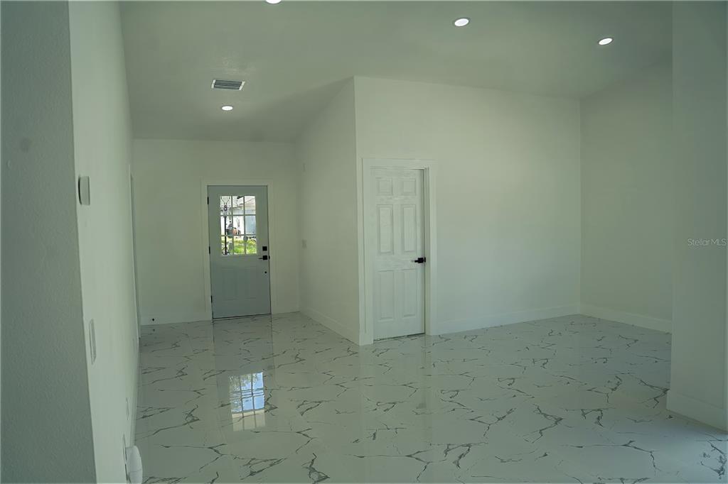 An interior view of a room with white walls, recessed lighting, and marble-patterned tile flooring — 9224 CAMINO VILLA BOULEVARD, TAMPA, FL