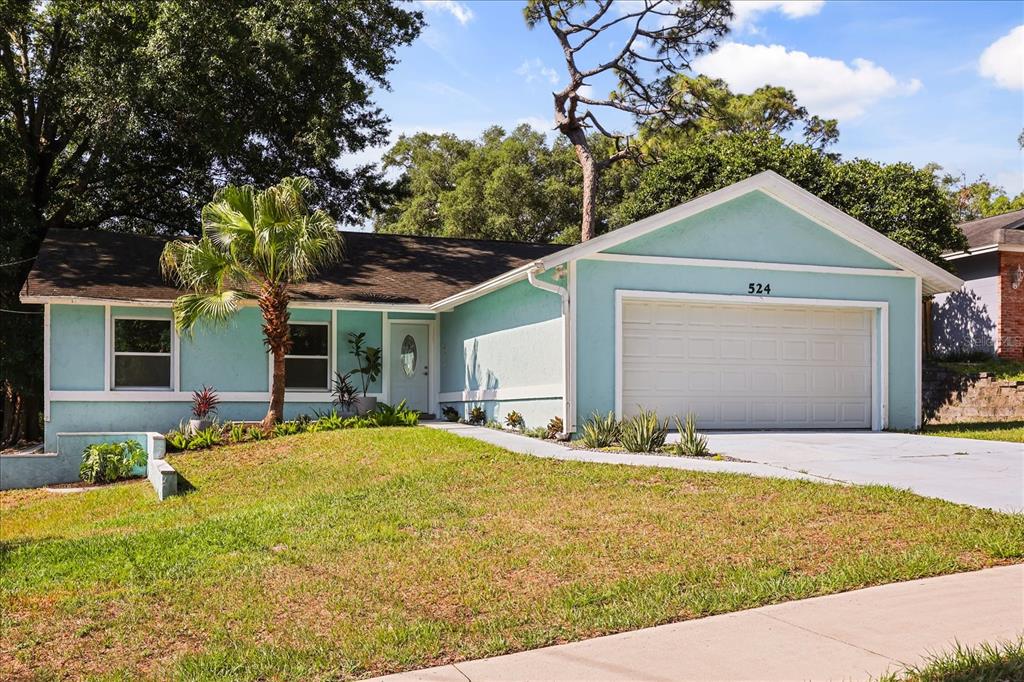 A light blue single-story house with a white garage door and a front lawn — 524 E HILLCREST STREET, ALTAMONTE SPRINGS, FL