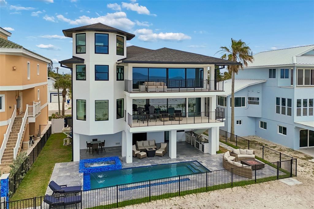 A three-story coastal home features a pool, spa, and balconies overlooking a sandy beach — 930 ELDORADO AVENUE, CLEARWATER BEACH, FL