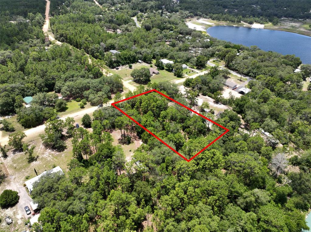 An aerial view shows a rectangular wooded lot outlined in red near a lake — 5630 LASSEN STREET, KEYSTONE HEIGHTS, FL
