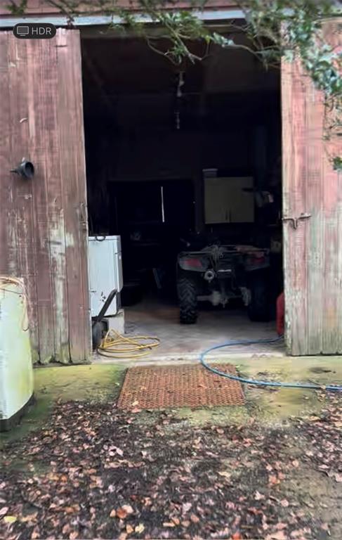 An open barn door reveals an interior space containing an ATV and a white appliance — 20231 PAINTER PLACE PLACE, SPRING HILL, FL