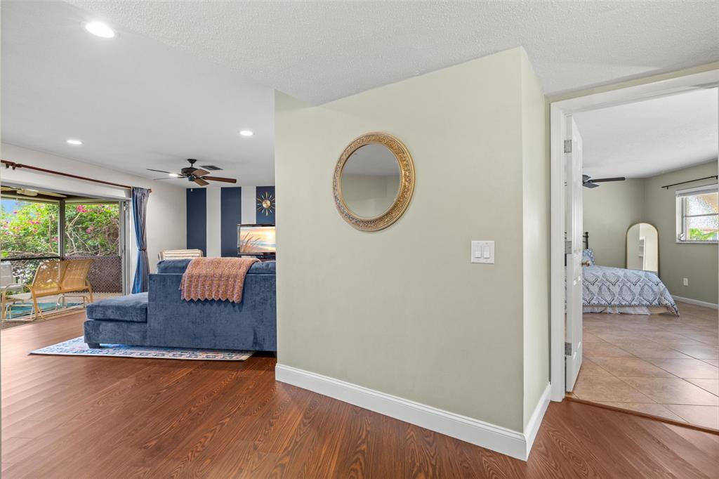 A view from a hallway looking into a living room and a bedroom — 6729 TEQUESTA DRIVE, SEMINOLE, FL