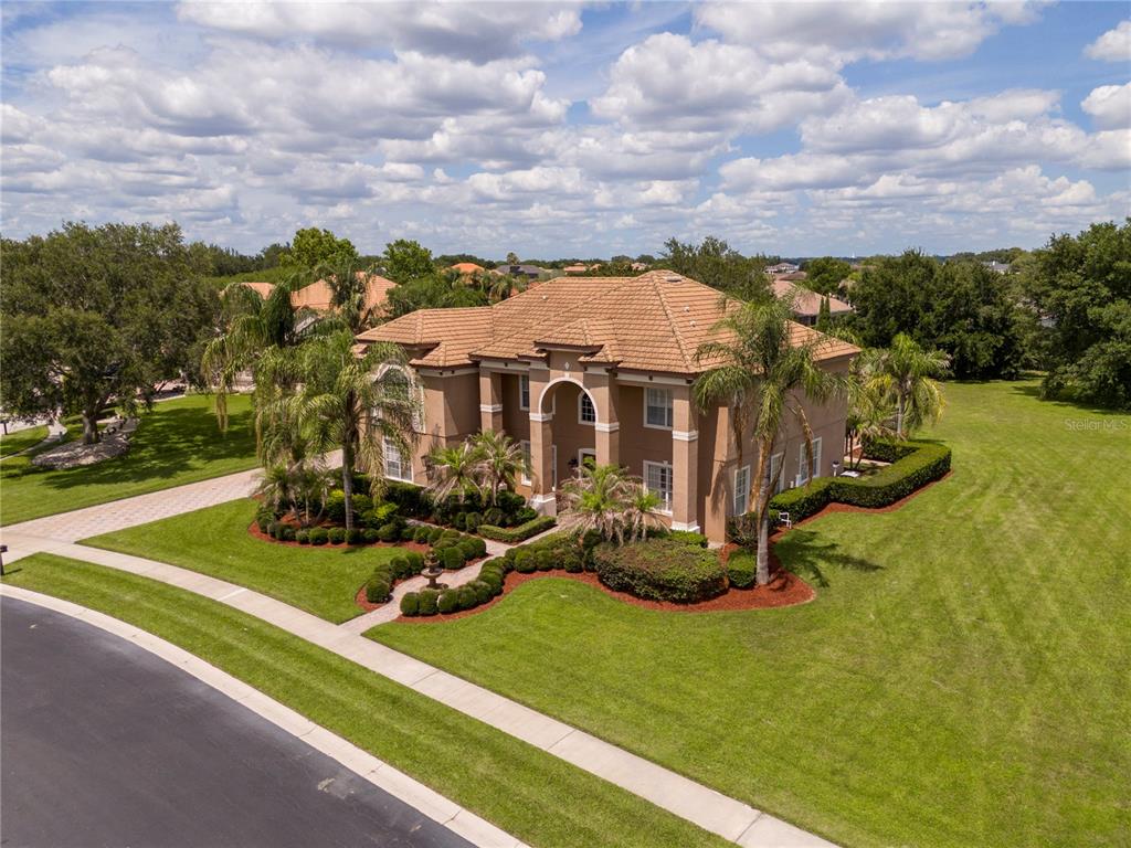 An aerial view of a two-story tan house with a tile roof and landscaped yard — 5741 OXFORD MOOR BOULEVARD, WINDERMERE, FL
