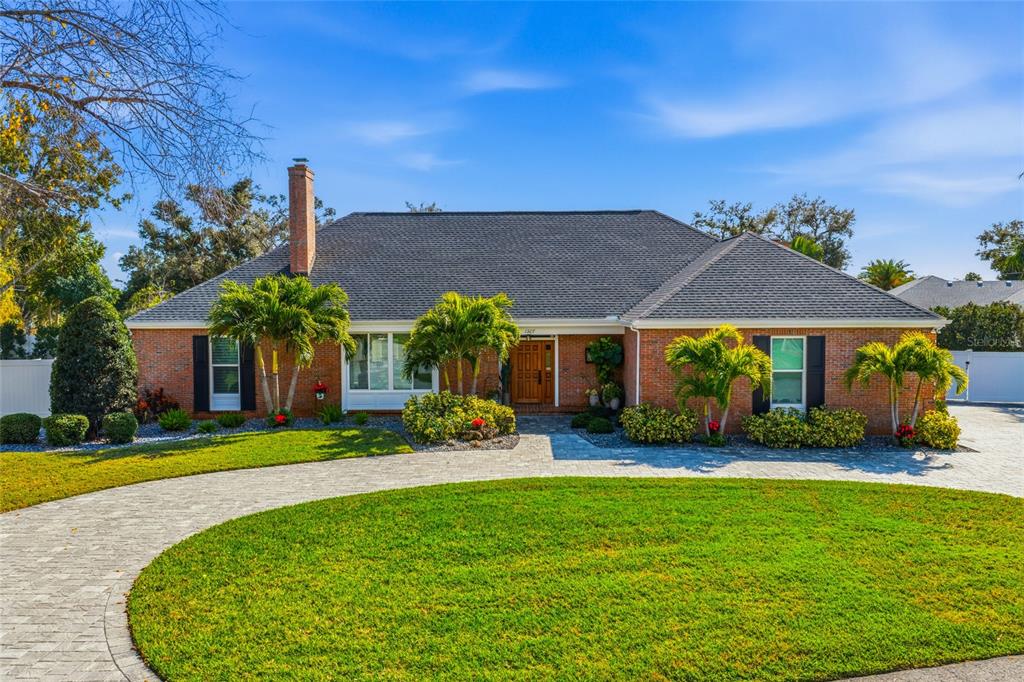 A single-story brick house with a circular paver driveway and a large front lawn — 1307 RIVERVIEW CIRCLE, BRADENTON, FL