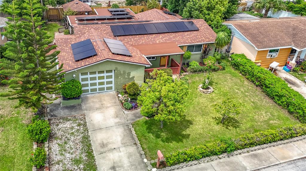 An aerial view of a single-story house with solar panels on a shingled roof — 3641 WELLINGTON DR, HOLIDAY, FL