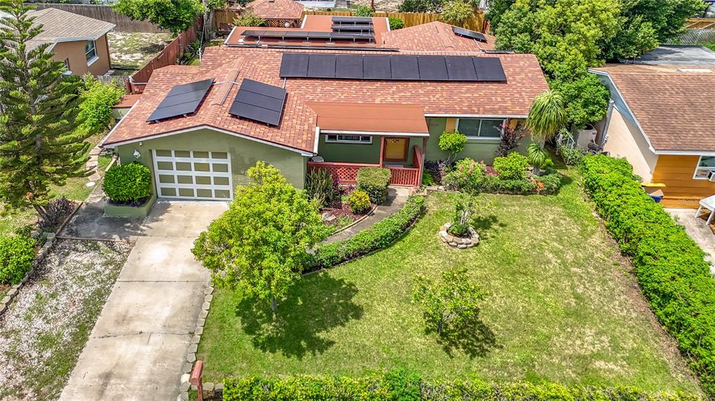 An aerial view of a single-story house with solar panels on the roof and lawn — 3641 WELLINGTON DR, HOLIDAY, FL