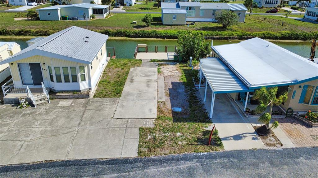 An aerial view shows two mobile homes separated by a concrete driveway and a canal — 1475 FLAMINGO DRIVE UNIT 389, ENGLEWOOD, FL