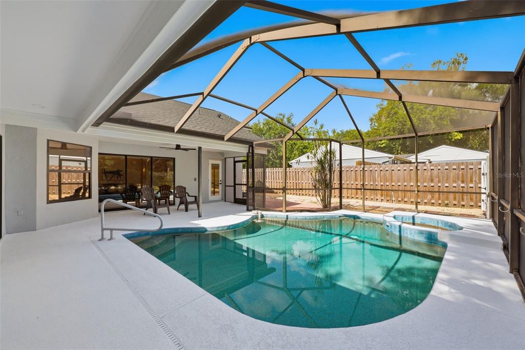 A screened-in patio features a swimming pool, a small spa, and a concrete deck — 3040 WINDRIDGE OAKS DRIVE, PALM HARBOR, FL