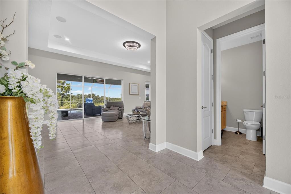 A tiled entryway leads to a living room with large glass doors and an adjacent bathroom — 5218 LAKE VENICE DRIVE, WIMAUMA, FL