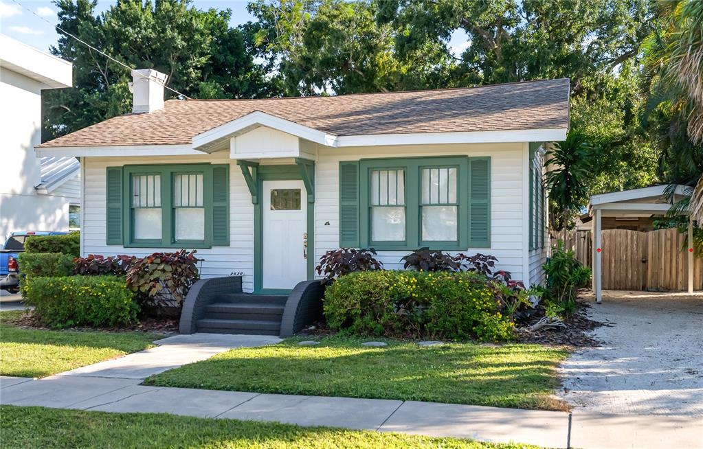 A white single-story house with green shutters and a small front porch with dark steps — 2530 LOMA LINDA STREET, SARASOTA, FL
