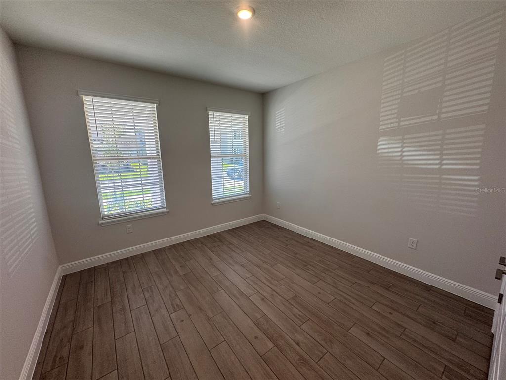 An entryway with light wood-look tile flooring, a white front door, and two interior doorways — 11857 SHINE VIEW LANE, WINTER GARDEN, FL
